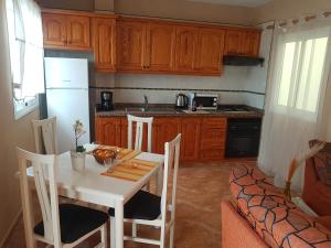 a kitchen with a table and chairs and a kitchen with a refrigerator at Apartamentos Las Salinas 2 in Caleta de Interián