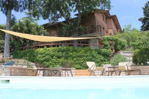 una piscina con sedie e una casa sullo sfondo di B&B Casa Sanni a Passignano sul Trasimeno