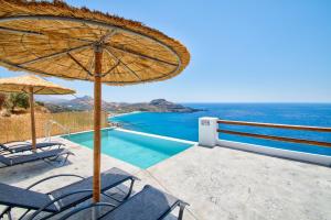 a patio with chairs and an umbrella and a swimming pool at Pyrgos Exclusive in Sellía