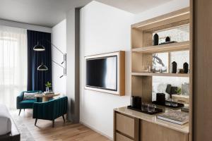 a living room with a television and a table and a chair at Kimpton - Pittman Hotel, an IHG Hotel in Dallas