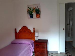 a bedroom with a bed with a purple bedspread and a nightstand at Balcón de Petralia in Petralia Soprana