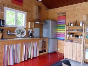 cocina con paredes de madera y nevera en Gîte Etchola, en Ramous