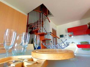 un tavolo con bicchieri da vino e una scala a chiocciola di Evelyn POOL apartment -only family- a Bardolino
