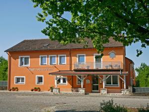 een groot oranje gebouw met een balkon aan de voorzijde bij Hotel An der Eiche in Kulmbach