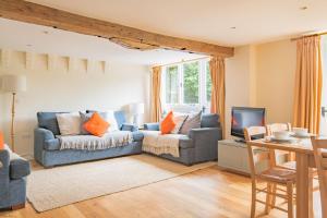 a living room with a couch and a tv at Great Higham Oast and Cottages by Bloom Stays in Canterbury