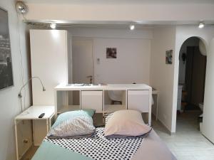 um quarto com uma secretária, uma cama e um lavatório. em Le centre Fontainebleau em Fontainebleau