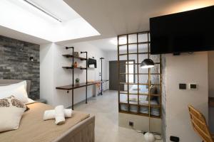 a bedroom with a bed and a tv on the wall at Orion Eco Suites in Karteros +37 photos