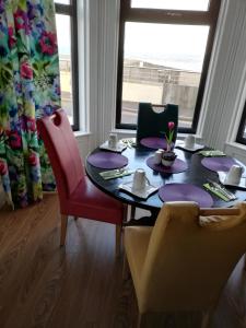 a dining room with a table with purple plates and chairs at Conlyn house in Newcastle