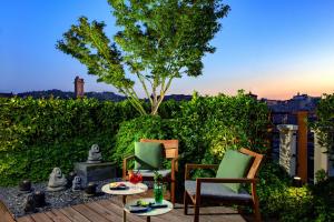 une terrasse avec 2 chaises et une cheminée dans l'établissement Hotel Metropolitan, à Bologne