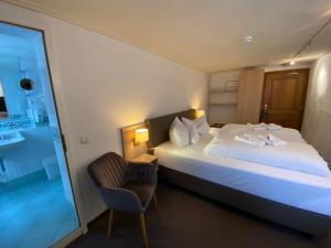 a hotel room with a bed and a chair at Horchem Hotel-Restaurant-Café-Bar in Monschau