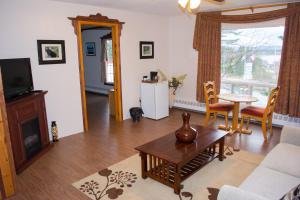 a living room with a couch and a table and a tv at Mayflower Inn in Roddickton