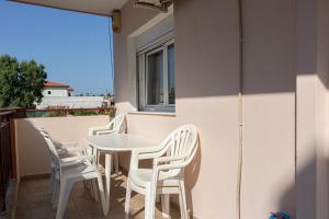 a white table and chairs on a balcony at JJ Rooms luxury apartments in Kallithea Halkidikis +89 photos