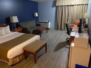 Slave LakeにあるNorthern Star Hotel & Convention Centerのベッド、ソファ、デスクが備わるホテルルームです。
