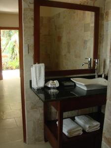 a bathroom with a sink and a large mirror at The Falls at Manuel Antonio in Manuel Antonio
