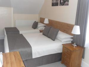 una camera con due letti e un tavolo con una lampada di Powys Lodge a Scarborough