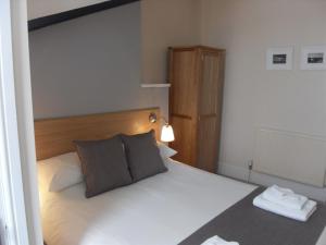 a bedroom with a white bed with a wooden headboard at Powys Lodge in Scarborough