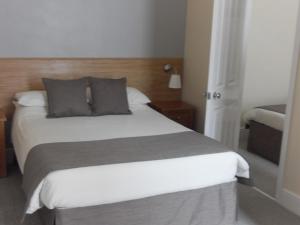 a bedroom with a large bed with two pillows at Powys Lodge in Scarborough