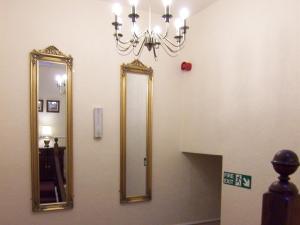 a bathroom with a mirror and a chandelier at Powys Lodge in Scarborough +2 photos