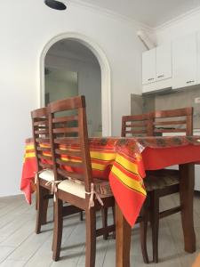 a table with chairs and a red and yellow table cloth at Eriola apartament in Orikum