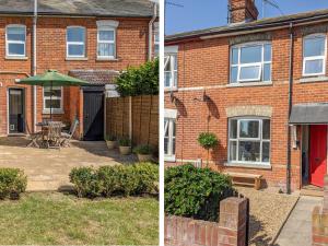 a brick house with a patio and an umbrella at Sea View Cottage in Frinton-on-Sea