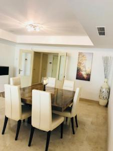 a dining room with a wooden table and white chairs at Lomas del Rey in Marbella