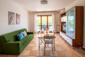 ein Wohnzimmer mit einem grünen Sofa und einem Tisch in der Unterkunft Accogliente Trilocale Turone a due passi dal mare in Martinsicuro