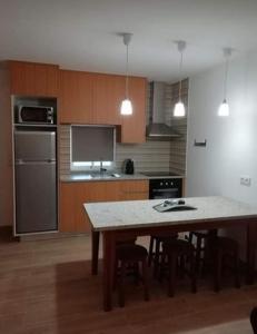 uma cozinha com uma mesa com cadeiras e um frigorífico em Casa Morgado em Braga