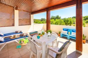 - un salon avec une table et des chaises sur une terrasse dans l'établissement Apartamentos Casa Brito, Boliqueime by AlgarveBlossom, à Boliqueime