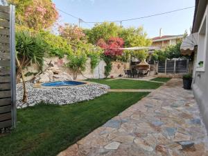 a backyard with a stone pathway and a swimming pool at Villa kontes kefalonia in Kardhakáta