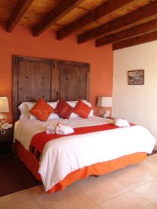 sypialnia z dużym łóżkiem z pomarańczowymi ścianami w obiekcie Casa del Tio Hotel Boutique w mieście San Miguel de Allende