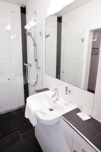 y baño blanco con lavabo y ducha. en Hotel Siebenschläfer, en Alsdorf