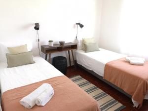 a room with two beds and a desk and a table at WOW OCEAN VIEW, 150mts to Beach & 10 min to Centre in Lagos