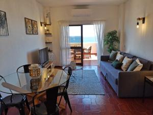 a living room with a couch and a glass table at WOW OCEAN VIEW, 150mts to Beach & 10 min to Centre in Lagos