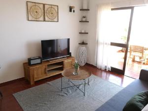 a living room with a flat screen tv and a table at WOW OCEAN VIEW, 150mts to Beach & 10 min to Centre in Lagos