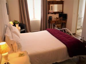 ein Schlafzimmer mit einem großen Bett mit einer roten Decke darauf in der Unterkunft Chez Edèll in Monpazier