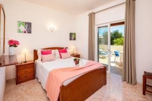 une chambre avec un grand lit et un balcon dans l'établissement Apartamentos Casa Brito, Boliqueime by AlgarveBlossom, à Boliqueime 39 autres photos