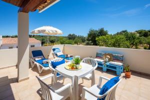 une terrasse avec une table et des chaises sur un balcon dans l'établissement Apartamentos Casa Brito, Boliqueime by AlgarveBlossom, à Boliqueime