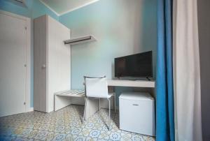 a room with a desk with a computer and a monitor at La stanza dell'angolo in Maratea