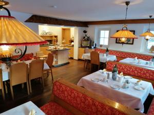 a restaurant with tables and chairs and a kitchen at Pension Heilbad Burgwies in Stuhlfelden