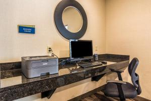 a desk with a laptop and a monitor on it at Cobblestone Hotel & Suites - Erie in Erie