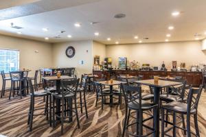 a restaurant with tables and chairs and a bar at Cobblestone Hotel & Suites - Erie in Erie