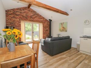 a living room with a couch and a table at Sunrise Stable in Spalding