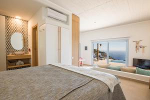 a bedroom with a bed and a view of the ocean at Two Goats Villas in Kyra Panagia