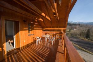 a wooden deck with two chairs and a table on it at Pension Studenov in Rokytnice nad Jizerou
