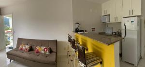 uma sala de estar com um sofá e uma cozinha com um balcão em Eco Ribeira em Angra dos Reis