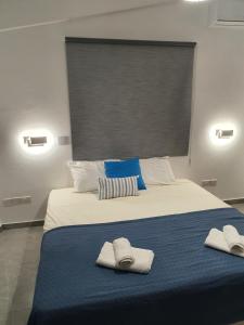 a bedroom with a bed with towels on it at Melanos Fully Renovated TownHouse with Private Pool in Paphos