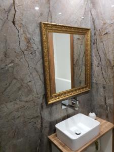 uma casa de banho com um lavatório branco e um espelho. em Melanos Fully Renovated TownHouse with Private Pool em Pafos