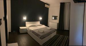 a bedroom with a bed and a black wall at Hotel Neyra Beach in Rimini