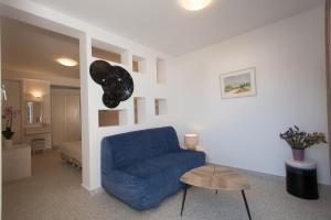 a living room with a blue couch and a table at Hotel Spanelis in Mikonos