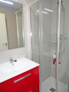 ein Badezimmer mit einem roten Schrank und einer Dusche in der Unterkunft MAR JÓNICA - Las marinas DENIA in Denia